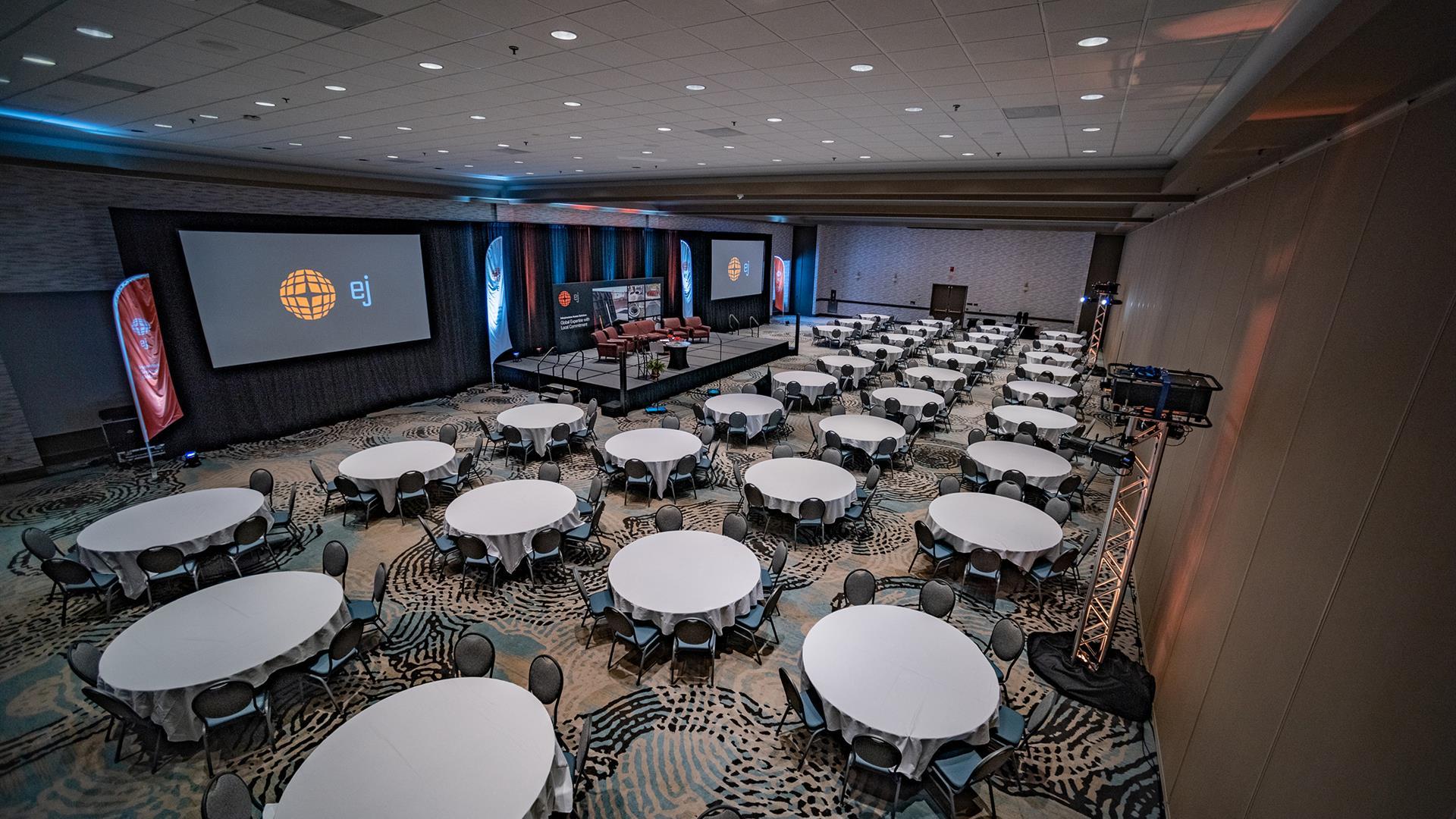 Govenors' Hall set up for a conference with tables and a stage. 